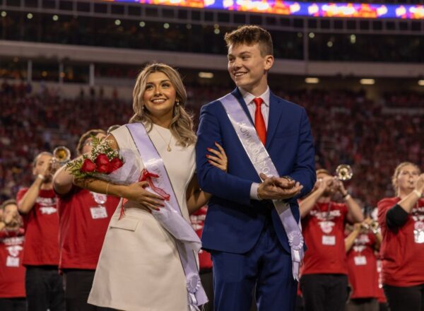 man and woman dressed with sashes for homecoming court