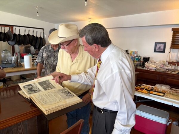 men looking at scrapbook