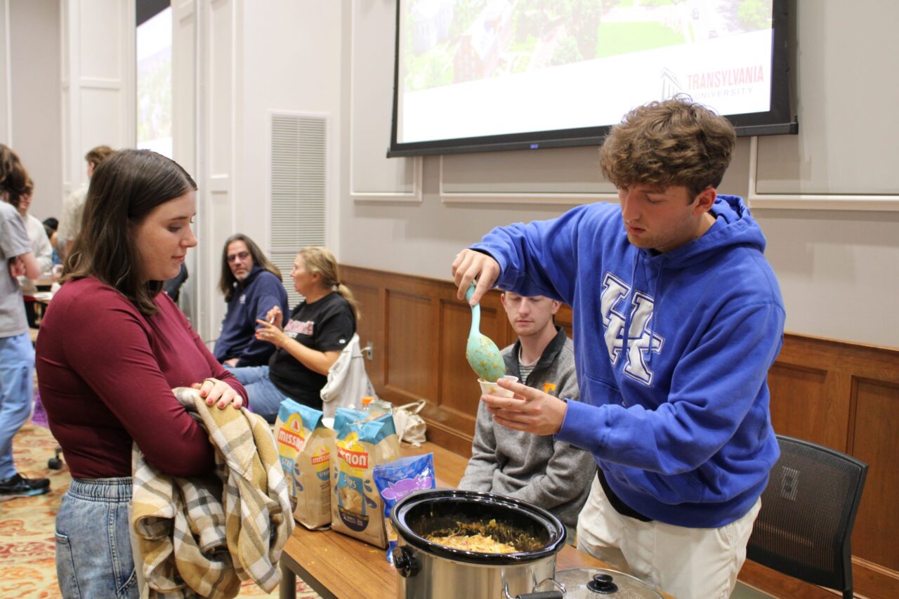 young man serving chili to young woman