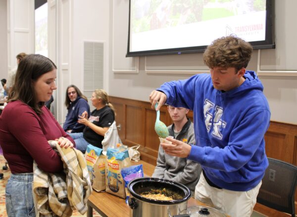 young man serving chili to young woman