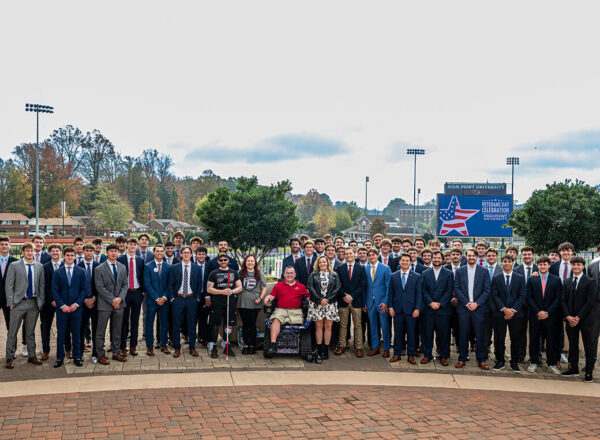 group of young men with wounded veterans in track chair