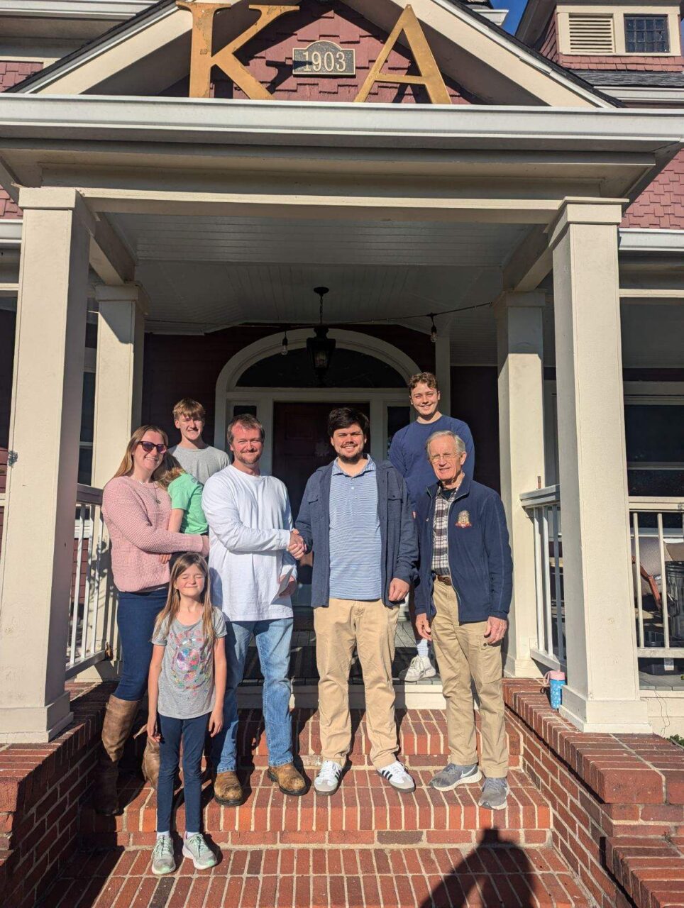 family on front porch of KA house