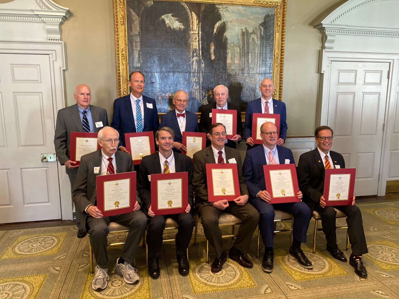 group of men sitting and standing with certificates