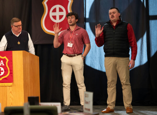 two men holding right hand up and reciting oath of office