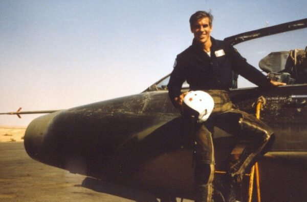 male pilot next to plane